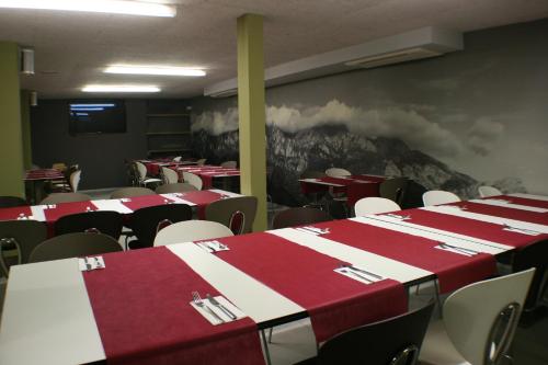 a dining room with red and white tables and chairs at Hotel Picos De Europa in Santander