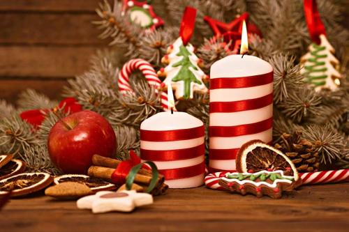 two red and white candles and christmas decorations on a table at Rambaldi Apartments Casa nr 5 in Bardolino
