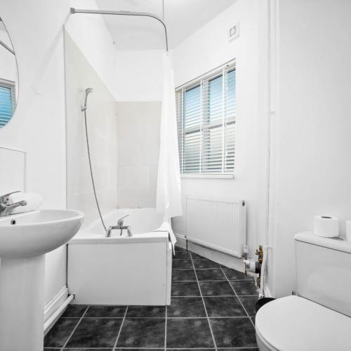 a white bathroom with a sink and a tub and a toilet at Modern Apartment - Smart TV & Netflix 7PC in Wolverhampton