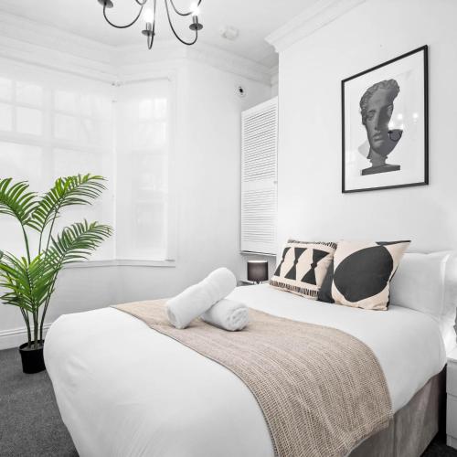 a bedroom with two beds and a potted plant at Modern Apartment - Pet Friendly - Fast Wi-Fi - Netflix - Wolverhampton 7PC in Wolverhampton