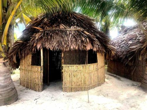 eine Hütte mit Strohdach am Strand in der Unterkunft CABAÑAS San-Blas PANAMÁ GUNAYALA-TRAVEL in Warsobtugua