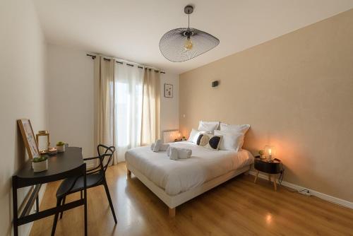 a bedroom with a bed and a desk with two lamps at Le Contempo in Veyrier-du-Lac