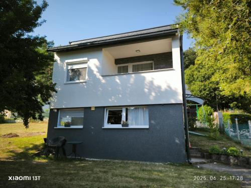 Casa blanca y azul con patio en Döbrönte MagLak, en Döbrönte