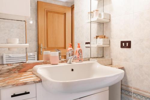 a bathroom with a white sink and a mirror at Casa Vacanza Le More in Cares