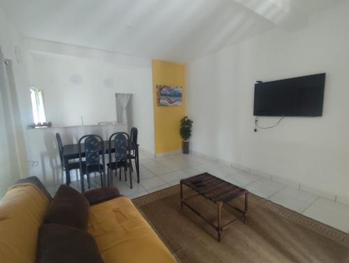 ein Wohnzimmer mit Couch und Flachbildfernseher in der Unterkunft Suíte Pé na areia in Santa Cruz Cabrália