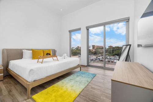 een slaapkamer met een bed en een groot raam bij 2BR2BA Condo w/ Pool & Gym – Walk to Palm Beach! in Palm-Eagle Beach