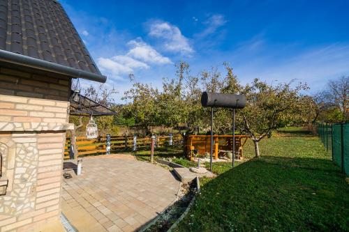 een achtertuin met een hek en een appelboom bij Non stop apartman in Kaposvár