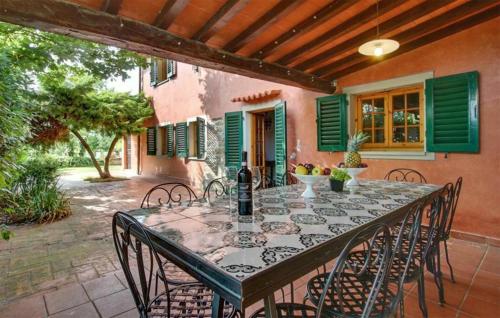 レッジェッロにあるGorgeous Home In Reggelloのダイニングテーブルと椅子付きのパティオ