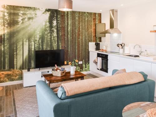 a living room with a blue couch and a tv at Elm - Uk50463 in Alvington