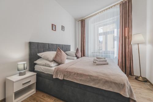 a bedroom with a large bed with a window at Stylový byt v srdci Hradce Králové in Hradec Králové