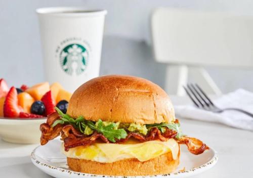 un panino su un piatto su un tavolo con un cesto di frutta di Courtyard By Marriott Jersey City Newport a Jersey City