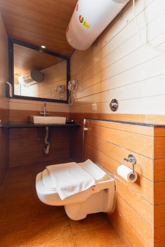 a bathroom with a toilet and a sink and a mirror at Sumitel Darjeeling in Darjeeling
