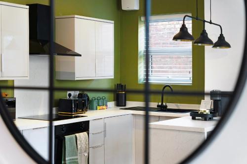 una cucina con armadi bianchi e pareti verdi di New! 2BR in Gladstone a Hartlepool