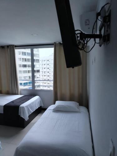 a hotel room with two beds and a window at Atardeceres del Laguito in Cartagena de Indias