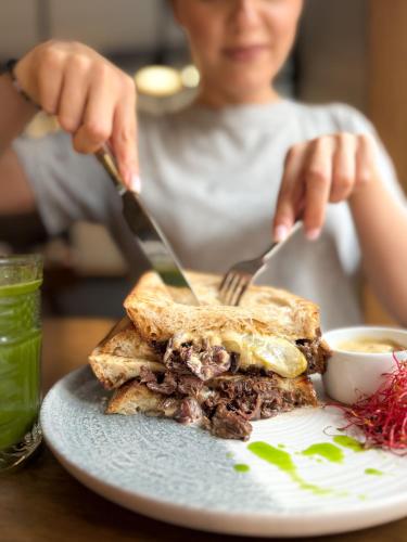 een vrouw die aan een tafel zit met een bord eten bij Moja apartments in Krakau