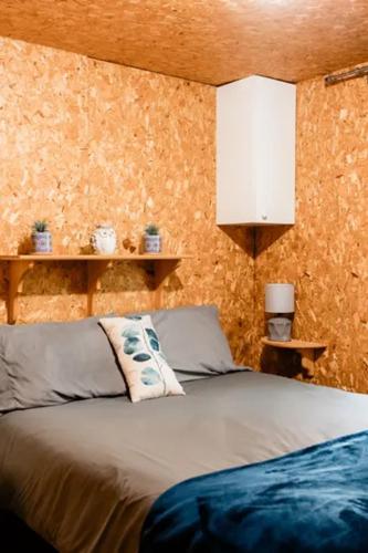 een slaapkamer met een bed in een kamer met oranje muren bij Chalet Le Mona in Notre-Dame-Des-Bois