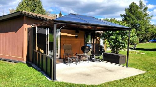 a gazebo with a grill in a yard at Charmant Petit Condo Ski in Val-Brillant