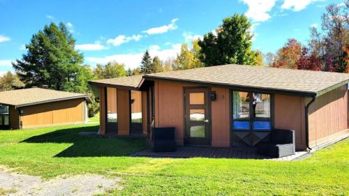 a small house with a porch on a lawn at Charmant Petit Condo Ski in Val-Brillant