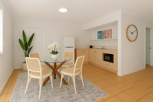een keuken en eetkamer met een tafel en stoelen bij Beachfront Bliss - At the Heart of It ALL in Townsville