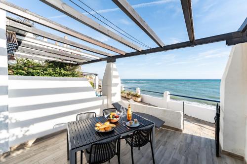 a patio with a table and chairs and the ocean at Calahonda Beach Apartments in Sitio de Calahonda