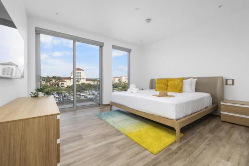een slaapkamer met een bed en een groot raam bij Relaxing 2BR2BA Condo w/ Gym, Pool in Palm Beach! in Palm-Eagle Beach