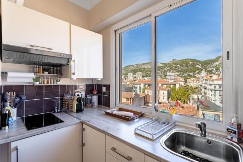 a kitchen with a sink and a large window at Splendide appartement climatisé vue mer in Toulon