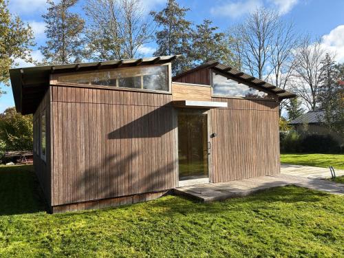 une petite maison en bois sur une pelouse dans l'établissement Bamboo House, à Boyl