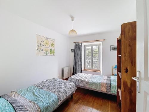 zwei Betten in einem Zimmer mit Fenster in der Unterkunft La petite Mainerie in Jobourg