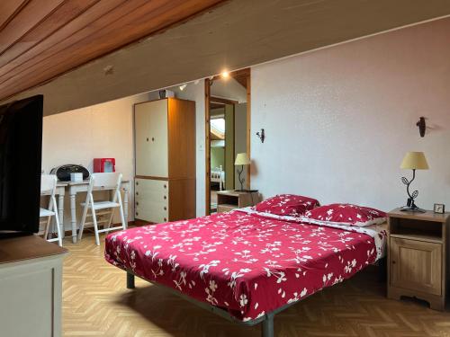 a bedroom with a bed with a red bedspread at Villa bord de mer Pays Basque Bidart - Biarritz - Guethary - St Jean de Luz in Bidart