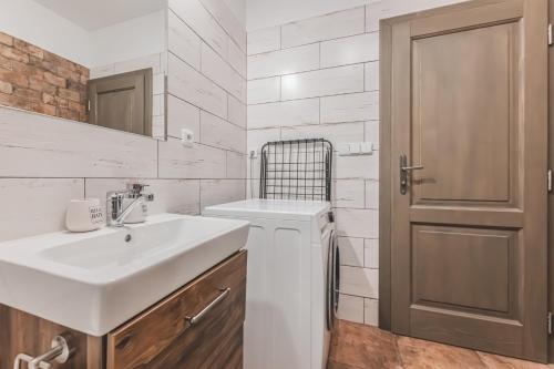 a white bathroom with a sink and a mirror at Podkrovní studio na Velkém náměstí s Wi-Fi zdarma in Hradec Králové