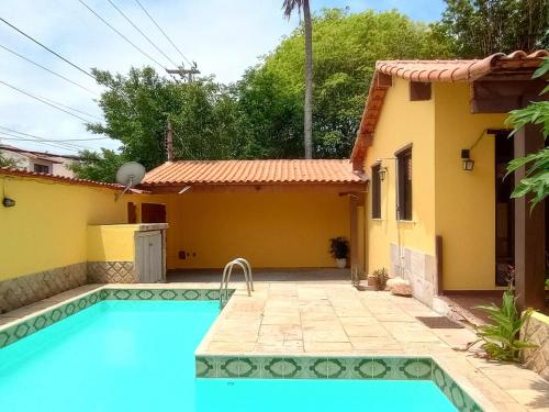 une villa avec piscine devant une maison dans l'établissement Casa independente com piscina emCabo Frio RJ, à Cabo Frio