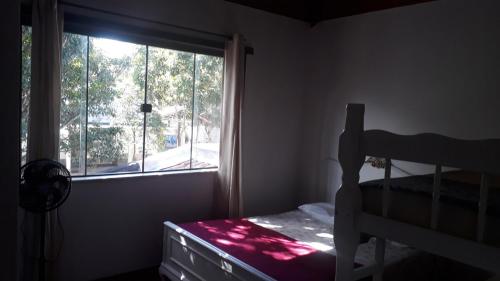 - une chambre avec une fenêtre, un lit et un lit dans l'établissement Casa independente com piscina emCabo Frio RJ, à Cabo Frio