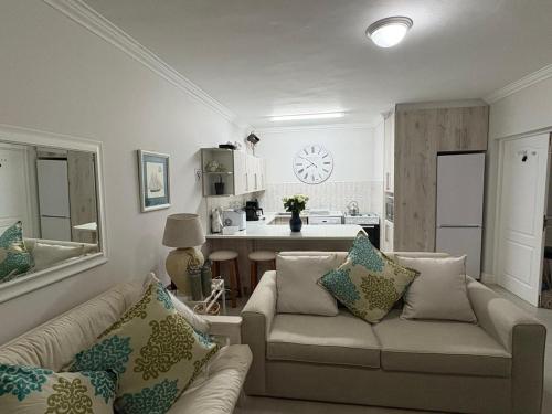 a living room with a couch and a kitchen at Keurbooms River in Keurboomstrand