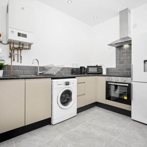 a white kitchen with a washer and dryer at Cozy Apartment - On street parking - Rowley Regis 49AG in Halesowen