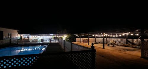 una piscina por la noche con luces en un edificio en Charming Jayuya room with City, Garden, and Mountain Views, en Jayuya