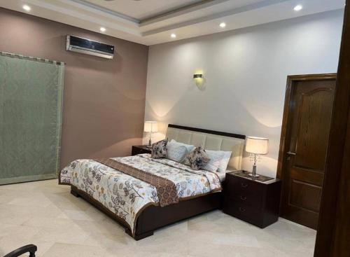 卡拉奇Galaxy Family Hotel Karachi Airport的一间卧室，配有一张床、两个床头柜和两盏灯