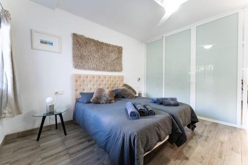 a bedroom with a bed with a blue comforter at Beach Side Apartments Calahonda in Sitio de Calahonda