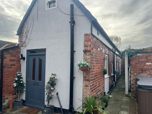 a white house with a blue door and a brick building at The Little Hexthorpe house in Doncaster