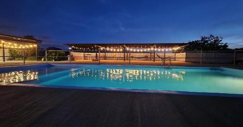 a swimming pool at night with lights around it at Main House 3BR, 3 Bath, Pool - 8 people in Jayuya