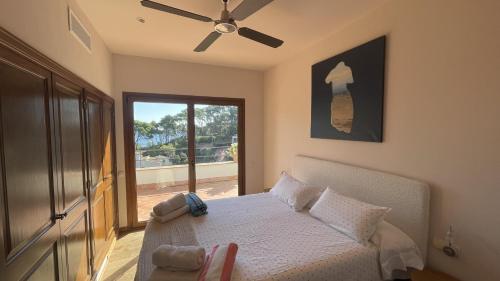 a bedroom with a bed with a ceiling fan at La Isla in Sa-Riera