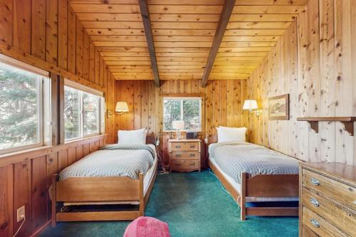 Chambers LodgeTahoe Getaway的一间木墙房间里有两张床