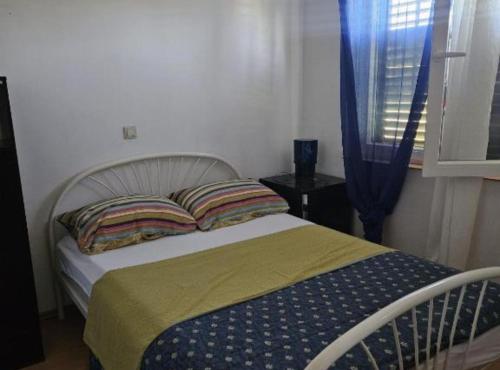 a bedroom with a bed with a blue and yellow blanket at Holiday Home Green Oasis Lika in Lovinac