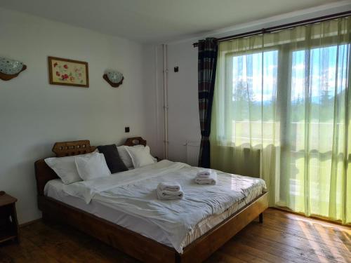 a bedroom with a large bed with towels on it at Zori de Zi & Apus de Soare in Bălceşti