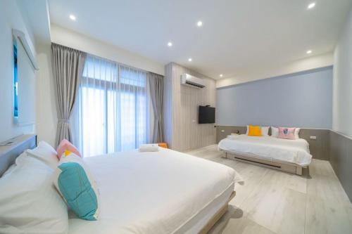 T'ung-koにある愛旅行民宿のベッドが2つと大きな窓がある寝室