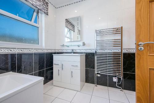a bathroom with a sink and a toilet and a window at Pebble Reach in Amroth