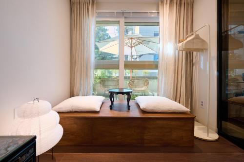 a room with two pillows and a table in front of a window at Seoul Station ㅣThe interior of a hanok with a terrace in Seoul