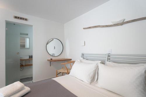 a bedroom with a bed with white pillows and a mirror at WHITE W4 new studio in Naousa in Naousa