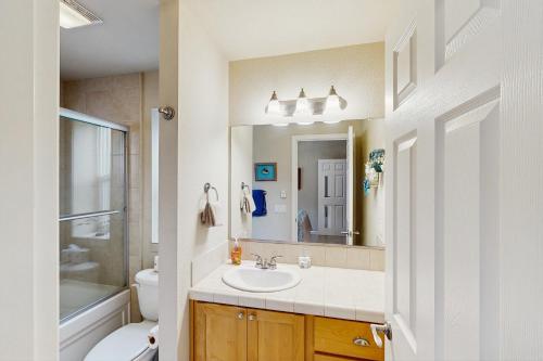 a bathroom with a sink and a toilet and a mirror at Ocean Lover's Landing in Gold Beach