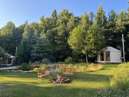 two benches sitting around a fire in a yard at Malá jurta na Souvrati in Mostek