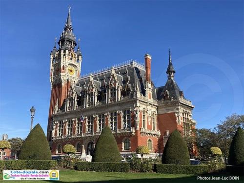 a large building with a clock tower on top of it at La Suite by Nath in Calais